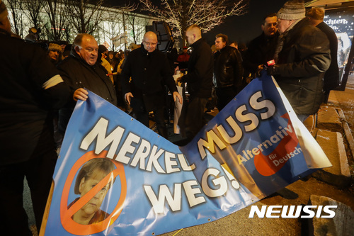 【베를린=AP/뉴시스】독일 우파 정당 '독일을 위한 대안'당 지지자들이 21일(현지시간) 베를린 총리관저 앞에서 "메르켈 퇴진하라"는 플래카드를 들고 있다. 2016.12.22 