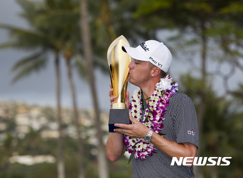 Justin Thomas kisses the trophy after winning the Sony Open golf tournament Sunday, Jan. 15, 2017, in Honolulu. (AP Photo/Marco Garcia)