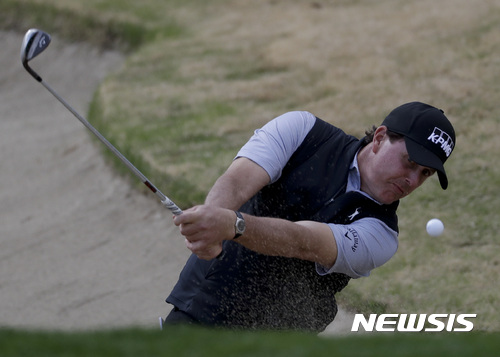 Phil Mickelson holes out from the bunker on the first hole during the second round of the CareerBuilder Challenge golf tournament on the Jack Nicklaus Tournament Course at PGA West Friday, Jan. 20, 2017, in La Quinta, Calif. (AP Photo/Chris Carlson)