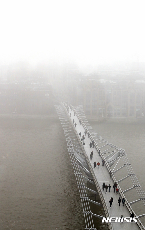 【런던=AP/뉴시스】영국 런던에 짙은 스모그가 깔린 가운데 시민들이 23일(현지시간) 세인트폴 대성당과 테이트 현대미술관을 잇는 밀레니엄교를 건너가고 있다. 영국 수도 런던도 이날 한파 속 심각한 대기오염으로 최고 수준의 대기오염 경고를 발령했다. 2017.01.24