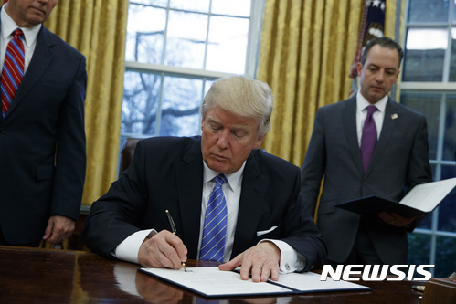 【워싱턴=AP/뉴시스】도널드 트럼프 미국 대통령이 23일(현지시간) 백악관 대통령 집무실에서 환태평양경제동반자협정(TPP)을 탈퇴한다는 내용의 행정명령에 서명하고 있다. 2017.1.24. 