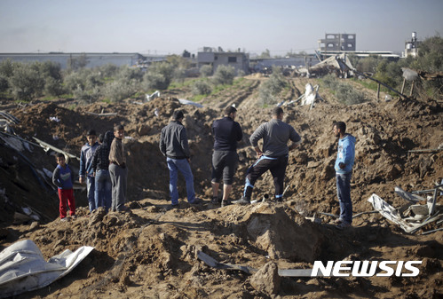【가자시티=AP/뉴시스】 팔레스타인 사람들이 지난2월 7일 가자시티에 대한 이스라엘군 폭격으로 푹 패인 구덩이를 바라보고 있다. 이스라엘 공군은 16일 새벽에도 팔레스타인 지역을 공습했다. 2017.03.16 