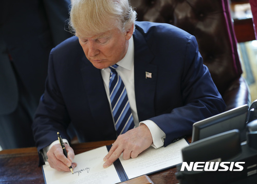 【워싱턴=AP/뉴시스】도널드 트럼프 미국 대통령이 9일(현지시간) 백악관 집무실에서 범죄를 줄이기 위한 행정명령 3개에 서명하고 있다. 2017.2.10. 