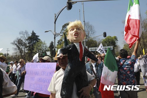 【멕시코시티=AP/뉴시스】멕시코 수도 멕시코시티에서 12일(현지시간) 한 여성이 '트럼프 인형'을 들고 시위를 벌이고 있다. 이날 시위에서 약 2만명이 참가했다. 2017.02.13 