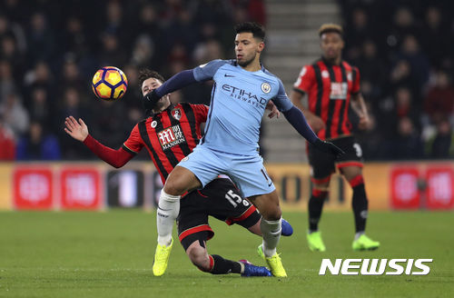 Manchester City's Sergio Aguero is challenged by AFC Bournemouth's Adam Smith during their English Premier League soccer match at the Vitality Stadium, Bournemouth, England, Monday, Feb. 13, 2017. (Andrew Matthews/PA via AP)