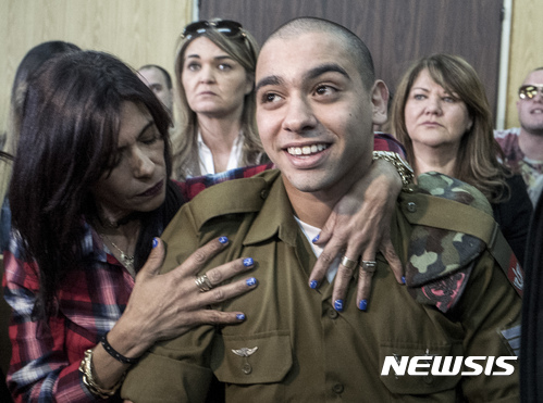 【텔아비브=AP/뉴시스】이스라엘 병사 엘로르 아자리아가 21일 형량이 선고되는 군사 법정에 들어가면서 어머니의 포옹을 받고 있다. 그는 이날 가벼운 1년반 징역형에 처해졌다. 2017. 2. 21. 