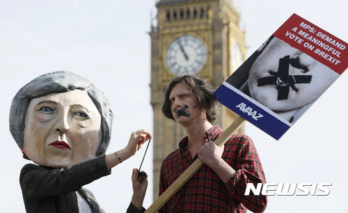 【런던=AP/뉴시스】영국 런던에서 13일(현지시간) 브렉시트(영국의 유럽연합(EU) 탈퇴) 강행에 반대하는 시위가 열렸다. 테리사 메이 총리의 인형탈이 협상 최종안에 대한 의회 표결을 요구하는 시위자의 입을 테이프로 막는 모습. 2017.3.14.