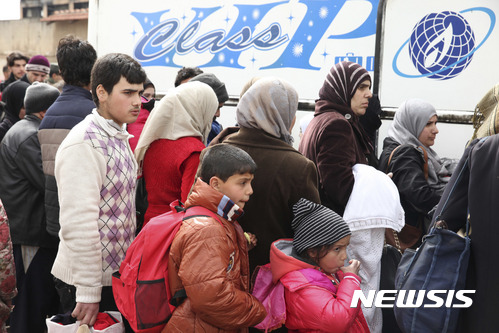 【홈스=AP/뉴시스】18일(현지시간) 시리아 홈스에서 민간인들이 터키 국경으로 향하는 버스 탑승을 기다리고 있다. 시리아 반군은 이날 정부와의 합의에 따라 홈스에서 철수를 시작했다. 2017.3.19. 