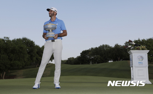 Dustin Johnson holds his trophy as he wait to pose for photos after defeating Jon Rahm of Spain at the Dell Technologies Match Play golf tournament at Austin County Club, Sunday, March 26, 2017, in Austin, Texas. (AP Photo/Eric Gay)