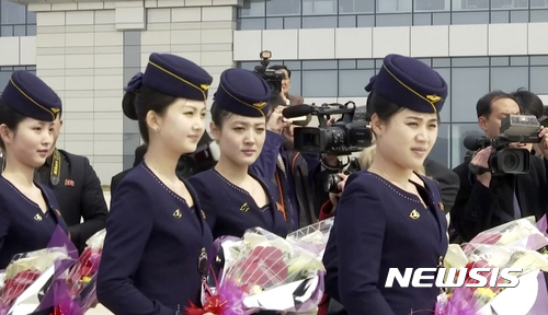 【평양=AP/뉴시스】북한 고려항공의 승무원들이 28일 단둥 신규 취항 여객기가 순안 공항에 도착하자 꽃을 들고 활주로에서 승객들을 기다리고 있다. 2017. 3. 28.  