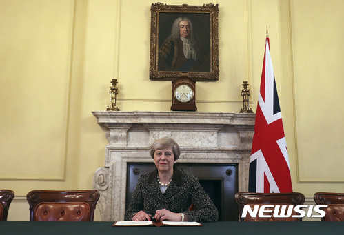 【런던=AP/뉴시스】테리사 메이 영국 총리가 28일(현지시간) 런던 총리관저에서 도널트 투스크 유럽이사회 의장에게 영국의 유럽연합 탈퇴를 통보하는 서한에 서명한 후 기념 촬영을 하고 있다. 벽에 걸린 초상화의 주인공은 초대 영국 총리 로버트 월폴이다. 2017.03. 29 