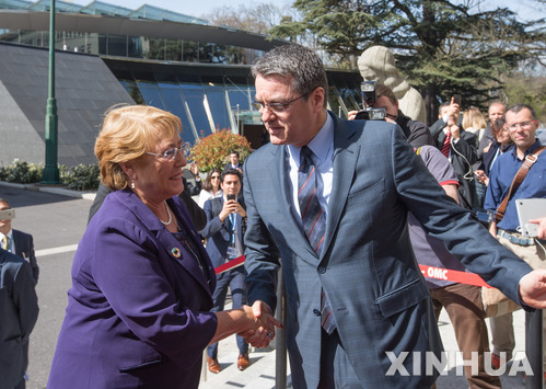 【 신화/뉴시스】=세계무역기구(WTO)의 호베르토 아제베도 사무총장이 미첼 바첼레트 칠레 대통령을 맞아 제네바의 회의장 앞에서 환영인사를 나누고 있다.  