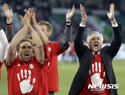 Bayern's head coach Carlo Ancelotti, right, and the players celebrate winning the German soccer champion title after the Bundesliga soccer match against VfL Wolfsburg in Wolfsburg, Germany, Saturday, April 29, 2017. (AP Photo/Michael Sohn)