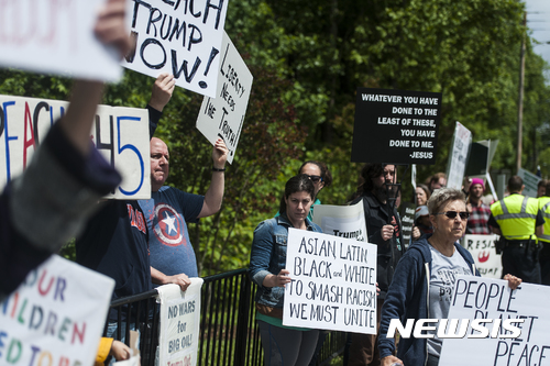 People protest along Wards Road as President Donald Trump speaks at the Liberty University commencement on Saturday, May 13, 2017, in Lynchburg, Va. (Lathan Goumas/News & Daily Advance via AP)