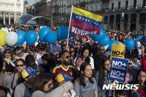 【마드리드( 스페인) = AP/뉴시스】 = 지난 4월 19일 스페인의 마드리드 거리에서 베네수엘라인들을 주축으로 한 시위대가 "독재와 살인을 중단하라"는 구호를 외치며 시위를 벌이고 있다. 니키 헤일리 유엔주재 미국대사는 17일(현지시간) 베네수엘라에 대한 유엔안보리 긴급회의를 소집한 뒤 이는 제2의 시리아나 북한, 남수단 같은 나라가 되지 않게 하기 위해서라고 설명했다.  