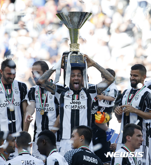 Juventus' Dani Alves lifts the trophy as Juventus players celebrate winning an unprecedented sixth consecutive Italian title, at the end of the Serie A soccer match between Juventus and Crotone at the Juventus stadium, in Turin, Italy, Sunday, May 21, 2017. (AP Photo/Antonio Calanni)