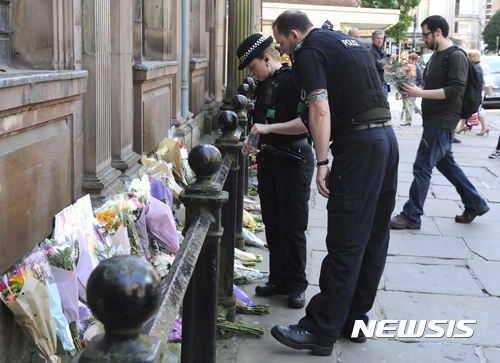 【맨체스터=AP/뉴시스】23일(현지시간) 영국 맨체스터의 세인트 앤스 스퀘어에서 경찰관들이 맨체스터 폭탄 테러 희생자들을 애도하고 있다. 2017.5.23. 