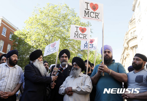 【맨체스터=AP/뉴시스】영국 맨체스터에서 23일(현지시간) 시크교 주민들이 "나는 맨체스터를 사랑한다"라고 쓴 팻말을 들고 전날 일어난 테러 희생자들을 추모하는 행사에 참석하고 있다. 2017.05.24 