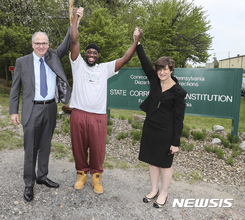 Shaurn Thomas, center, poses for a photo with attorneys James Figorski and Marissa Bluestine of the Pennsylvania Innocence Project after leaving the Frackville Correctional Institution on Tuesday, May 23, 2017, in Frackville, Pa. Thomas was exonerated after spending 24 years in prison. (Steven M. Falk/The Philadelphia Inquirer via AP)