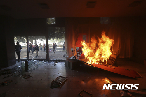 【브라질리아=AP/뉴시스】미셰우 테메르 브라질 대통령의 퇴진을 요구하는 반정부 시위대가 24일(현지시간) 수도 브라질리아에서 화염병을 던져 농무부 청사 1층 시설이 불타고 있다. 2017.05.25  