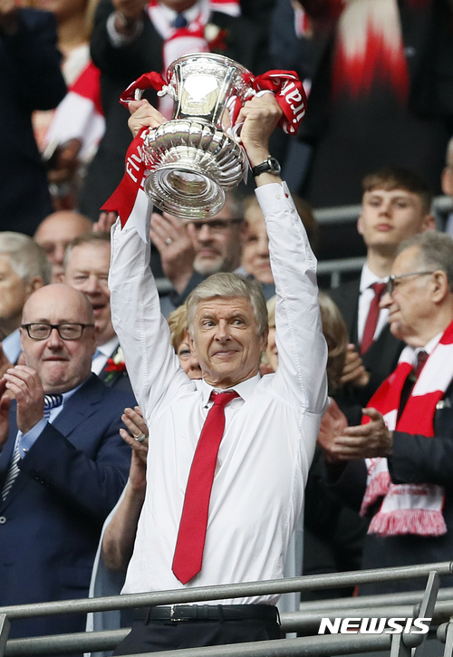 Arsenal team manager Arsene Wenger celebrates with the trophy after winning the English FA Cup final soccer match between Arsenal and Chelsea at Wembley stadium in London, Saturday, May 27, 2017. Arsenal won 2-1. (AP Photo/Kirsty Wigglesworth)