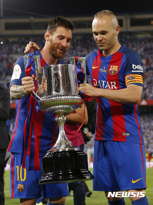 Barcelona's Lionel Messi, left, and Barcelona's Andres Iniesta hold the cup after winning the Copa del Rey final soccer match between Barcelona and Alaves at the Vicente Calderon stadium in Madrid, Spain, Saturday May 27, 2017. (AP Photo/Daniel Ochoa de Olza)