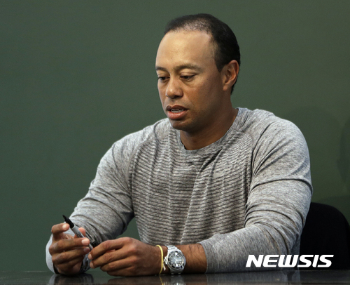 FILE - In this March 20, 2017, file photo, golfer Tiger Woods prepares to sign copies of his new book at a book signing in New York. Police say golf great Tiger Woods has been arrested on a DUI charge in Florida. The Palm Beach County Sheriff's Office says on its website that Woods was booked into a county jail around 7 a.m. on Monday, May 29, 2017. (AP Photo/Seth Wenig, File)