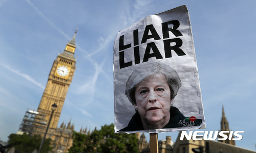【런던=AP/뉴시스】21일(현지시간) 영국 런던의 국회의사당 인근에서 그렌펠 타워 화재 진상 규명을 촉구하는 시위가 열리고 있다. 사진은 한 시위자가 테리사 메이 영국 총리는 거짓말쟁이'(liar)라고 적힌 푯말을 들고있는 모습. 2017.6.22.
