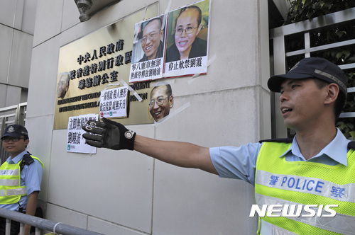 【홍콩=AP/뉴시스】 주홍콩 중국연락판공실 건물 앞에서 27일 경찰들이 간암 말기 판정을 받고 가석방된 인권운동가 류샤오보의 무조건적인 석방을 요구하는 시위대의 접근을 막고 있다. 2017.06.27 