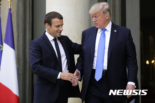 【파리=AP/뉴시스】에마뉘엘 마크롱 프랑스 대통령(왼쪽)과 도널드 트럼프 미국 대통령이 13일(현지시간) 파리 엘리제궁에서 만나 인사하고 있다. 2017.7.14. 
