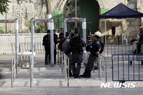 【예루살렘 = AP/뉴시스】 = 예루살렘 알아크사 회교사원 앞의 금속탐지기가 설치된 검문대 앞에서 7월 24일 사람들이 이스라엘 경찰의 검문을 받고 있다.  무슬림의 반발이 심하자 이스라엘 정부는 다른 첨단 기기로 바꾸기로 결정했다고 밝혔다. 