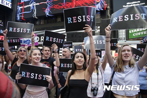 【뉴욕 = AP/뉴시스】차미례 기자 = 26일 도널드 트럼프 대통령이 앞으로 성전환자의 미군복무를 금지시키겠다고 발표하고 난 뒤 뉴욕 시내 타임스 스퀘어에 모인 시위대가 "저항"이란 팻말을 들고 대규모 반대시위를 벌이고 있다.   