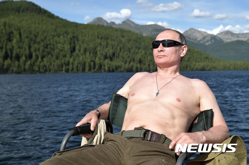  【모스크바=AP/뉴시스】블라디미르 푸틴 러시아 대통령이 며칠 전 시베리아 티바 지역에서 휴가 중 낚시를 마친 뒤 휴식을 취하고 있다. 이 사진은 5일 크렘린궁이 배포했다. 2017.8.6 