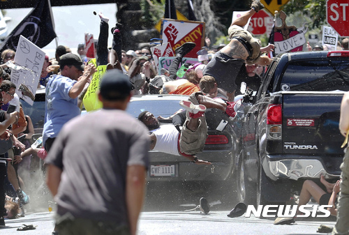 【샬러츠빌(버지니아)=AP/뉴시스】 12일(현지시간) 미국 버지니아 주 샬러츠빌에서 백인 극우파 집회에 반대하는 시위단체의 거리 평화행진 도중 은색 차량(사진) 한 대가 시위대로 돌진했다. 사진은 이 차량이 시위대를 무차별적으로 들이받아 사람들이 공중으로 튕겨져 나가는 모습. 이 과정에서 1명이 사망하고 19명이 다쳤다. 2017.08.13. 