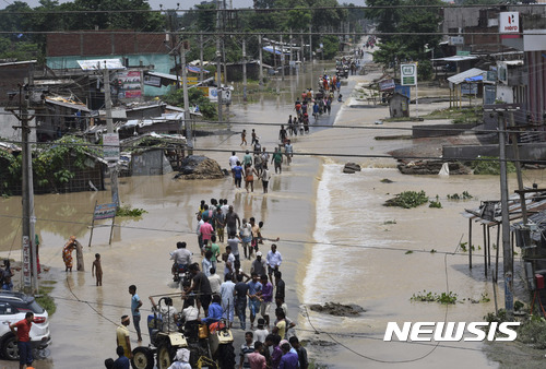 【아라리아(인도)=AP/뉴시스】최근 인도 동부와 북부, 네팔, 방글라데시 등 지역에서 몬순에 따른 폭우와 산사태 등으로 600명 가까이 숨지고 약 1600만 명 이상 이재민이 발생했다. 지난 14일 홍수 피해가 발생한 비하르주 아라리아 지역에서 주민들이 대피하고 있는 모습. 2017.08.20 