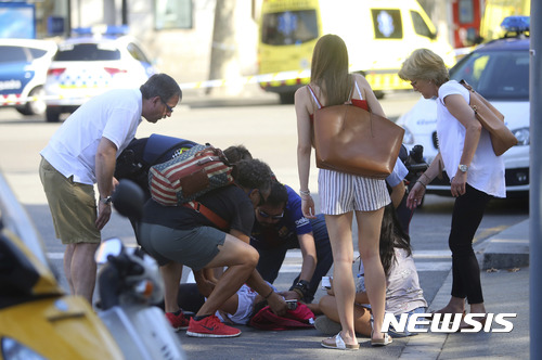 【 바르셀로나=AP/뉴시스】스페인 바르셀로나에서 17일(현지시간) 시민과 관광객들이 차량 돌진 테러로 다친 사람을 돌보고 있다. 2017.08.18
