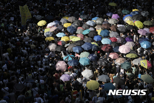 【홍콩=AP/뉴시스】 20일 홍콩 시민들이 2014년 민주화 '우산 혁명' 주도자들인 조슈아 웡 등 3명을 법정구속시킨 항소심 판결에 항의하는 시위에 우산을 쓰고 참여하고 있다. 2017. 8. 20.