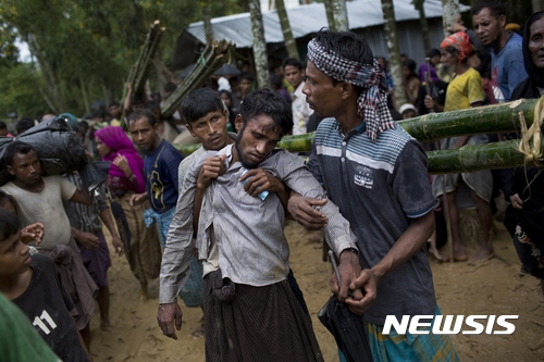 【쿠투팔롱=AP/뉴시스】방글라데시 쿠투팔롱에서 9일(현지시간) 한 남성이 구호기관이 나눠주는 쌀을 받기 위해 기다리다가 탈진하자 다른 남성들이 부축하고 있다. 2017.09.11 