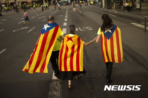 【바르셀로나=AP/뉴시스】스페인 헌법재판소가 9월12일 카탈루냐주의 임시 헌법이 될 수 있는 법의 효력을 정지시켜 카탈루냐주의 독립에 또 다시 제동을 걸었다. 사진은 지난 11일 바르셀로나에서 일가족이 카탈루냐 국기를 목에 두르고 집회에 참가하는 모습. 2017.09.13 
