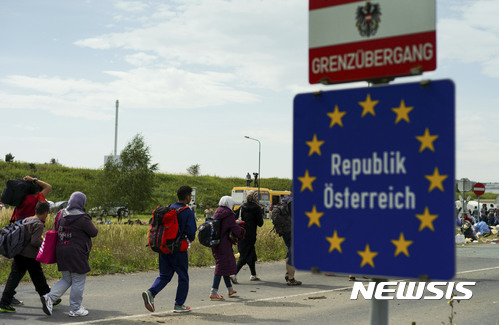 【헤일링겐크로이츠 = AP/뉴시스】 2015년 9월 14일 오스트리아와 헝가리 국경지대인 헤일링겐크로이츠에서 난민 행렬이 도보로 지나가고 있다. 오스트리아 정부는 독일이 자국내 고속도로 요금소를 설치하는 안에 대해 유럽연합 재판소에 설치 금지를 명령해달라며 제소했다. 2017.10.13    