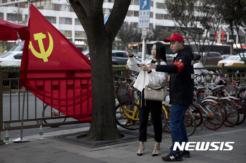 【베이징=AP/뉴시스】 제19차 중국 공산당대회를 이틀 앞둔 16일, 베이징 거리에서 한 남성이 여성에게 길을 가르쳐주고 있다. 2017.10.17