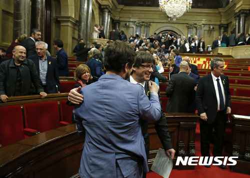 【바르셀로나=AP/뉴시스】 스페인 카탈루냐의 카를레스 푸지데몬 수반(중앙오른쪽)이 27일 지방의회가 독립국 설립안을 압도적으로 가결한 뒤 만난 의원과 축하하며 서로 등을 두드리고 있다. 독립 반대 의원들은 투표 전 퇴장했다. 2017. 10. 27.   
