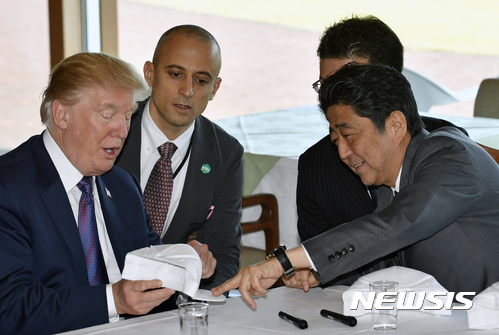【가와고에=AP/뉴시스】도널드 트럼프 미국 대통령이 5일 일본 사이타마 현 가와고에에 있는 가스미가세키 골프장에서 아베 신조 총리에게 자신이 서명한 골프모자를 보여주고 있다. 2017.11.05