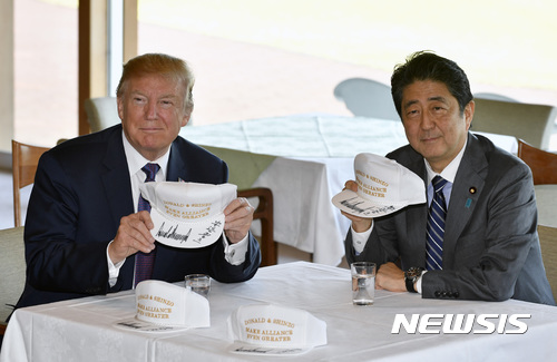 【가와고에=AP/뉴시스】도널드 트럼프 미국 대통령과 아베 신조 일본 총리가2017년 11월  5일 사이타마 현 가와고에에 있는 가스미가세키 골프장에서 각자 서명한 골프모자를 들어보이고 있다.  2017.11.05 