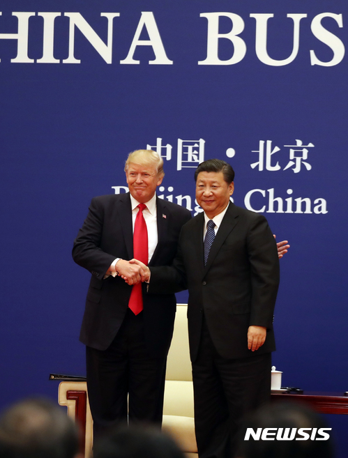 【베이징=AP/뉴시스】도널드 트럼프 미국 대통령과 시진핑 중국 국가주석이 9일 베이징 인민대회당에서 미중 기업 간의 협약식에 참석해 악수하고 있다. 2018.11.09