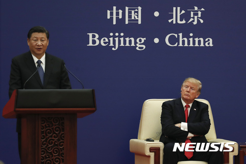 【 베이징=AP/뉴시스】 도널드 트럼프 미국 대통령이 중국에 대한 관세를 완화할 의도가 없으며 중국 지도자들이 관세 문제로 더 많은 고통을 느끼기를 원하고 있다고 악시오스가 21일 보도했다. 사진은 트럼프 대통령이 2017년 11월 9일 베이징 인민대회당에서 열린 미중 기업인 행사에서 시진핑 중국 국가주석의 연설을 듣고 있는 모습. 2018.10.22
