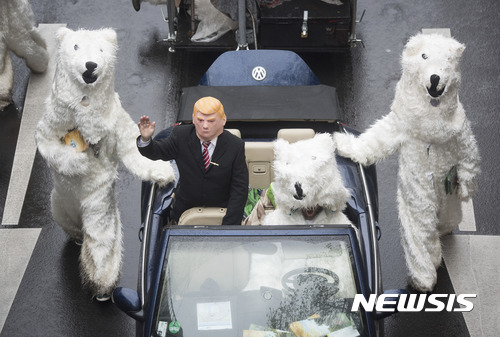 【 본=AP/뉴시스】제23차 유엔기후변화협약 당사국 총회(COP23)가 열리고 있는 독일 본에서 11일(현지시간) 도널드 트럼프 미국 대통령 가면을 쓴 남성이 북극곰 탈을 쓴 '경호원'을 대동하고 카퍼레이드를 벌이고 있다. 트럼프 대통령은 미국의 파리 기후변화 대응 협약 탈퇴를 선언한 바 있다. 2017.11.14 