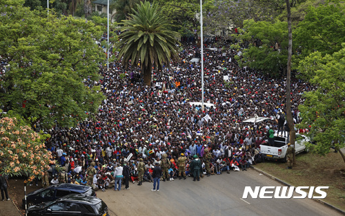 【하라레=AP/뉴시스】 짐바브웨 군부가 로버트 무가베 대통령을 가택연금시킨 나흘째인 18일 수만 명의 수도 주민들이 군 비상선 앞에 모여 무가베의 퇴진을 요구하는 시위를 벌이고 있다. 며칠 전만 같은면 경찰의 무자비한 진압이 터져나왔을 시위는 이날 평화롭게 끝났다. 2017. 11. 19.  