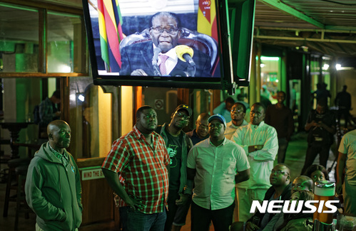 【하라레( 짐바브웨 ) = AP/뉴시스】 =19일 밤(현지시간) 짐바브웨 국민들이 로버트 무가베대통령의 사퇴발표를 기대하며 TV연설을 시청하다가 끝까지 사퇴언급이 없자 실망과 분노를 표하고 있다.  