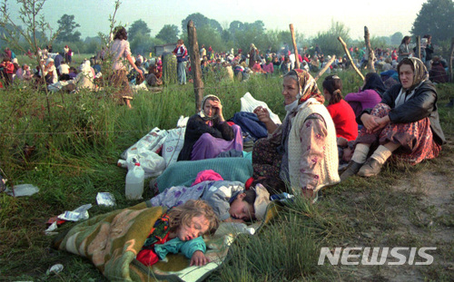 【AP/뉴시스】 1995년 7월14일 발칸반도 보스니아 전쟁 때 독립을 반대하는 세르비아계 민병대들이 유엔평화군을 무력화시키고 스레브레니카 지역의 보스니아 무슬림 남자 어른 남자 어린이 8000여 명을 집단 학살했다. 사진은 민병대에 의해 마을에서 쫓겨나 인근 투즐라 유엔기지 앞에 피신해 밤을 새운 스레브레니카의 여성들 모습이다. 스레브레니카 학살 원흉인 '발칸의 도살자' 라트코 믈라디치가 유엔 유고특별전쟁범죄재판소로부터 22일 선고 판결을 받는다. 2017. 11. 21. 